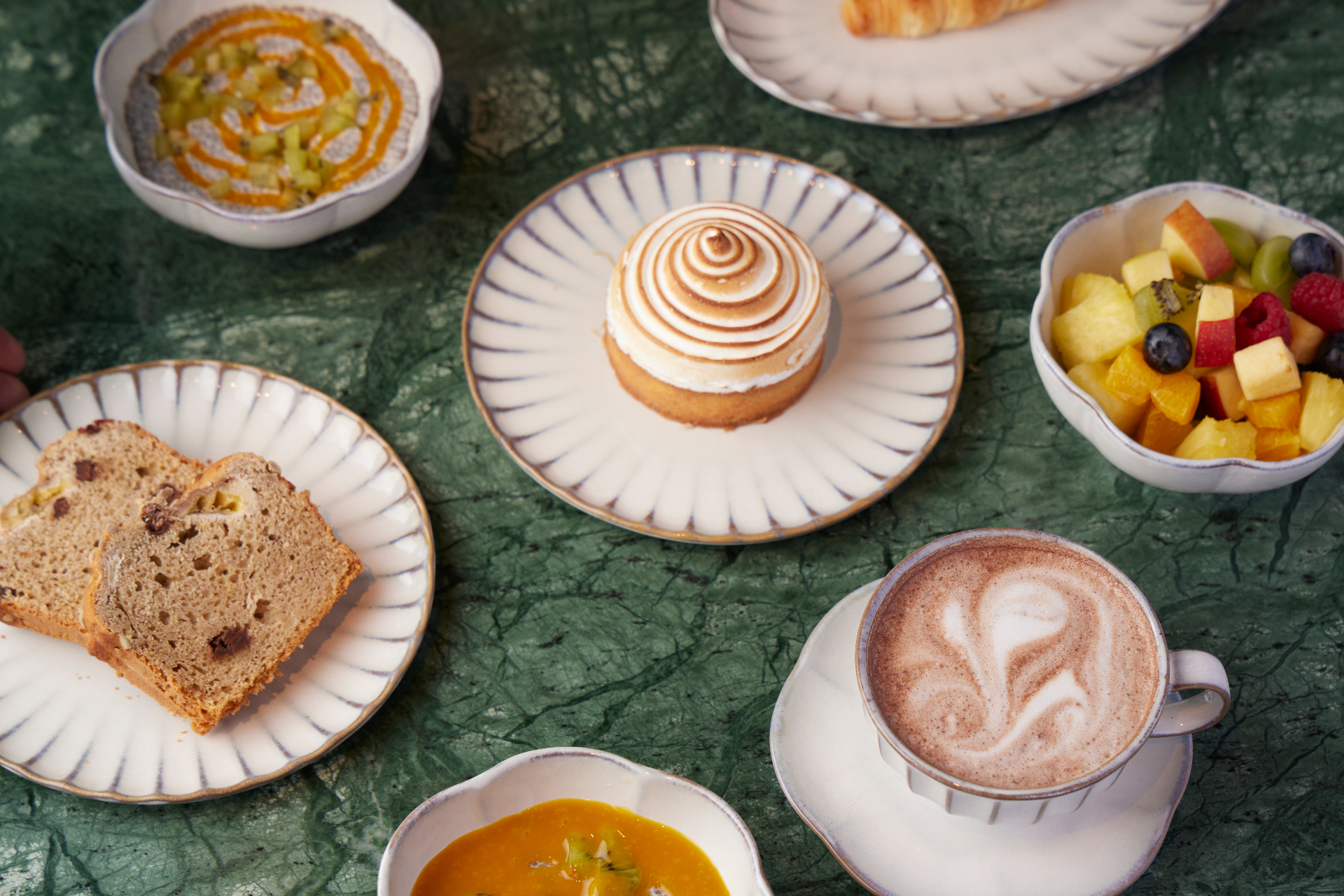 Pastries, fruit and coffee on a marble table at Cafe Gaia
